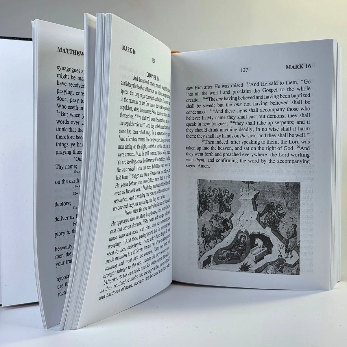 Open book with text and a black and white illustration on a white background