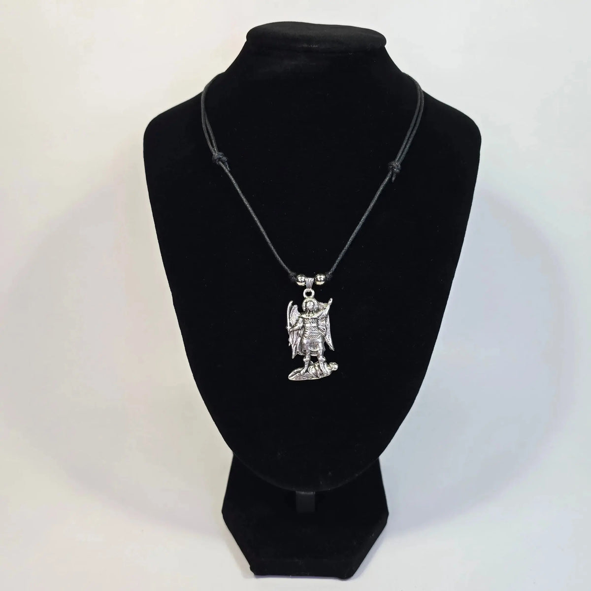 Necklace with a pendant on a black velvet stand against a white background