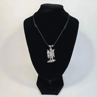 Necklace with a pendant on a black velvet stand against a white background
