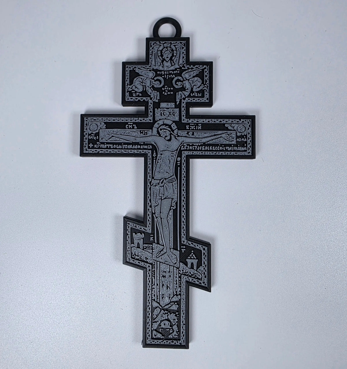 Black 3D-printed Orthodox crucifix with gray iconographic relief and hanging loop