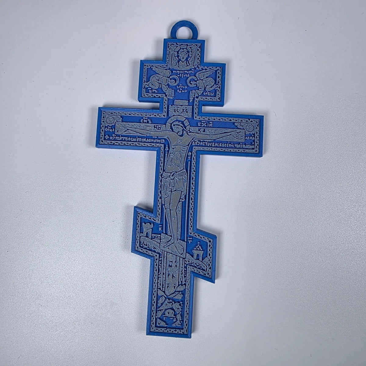 Blue 3D-printed Orthodox crucifix with gray iconographic relief and hanging loop